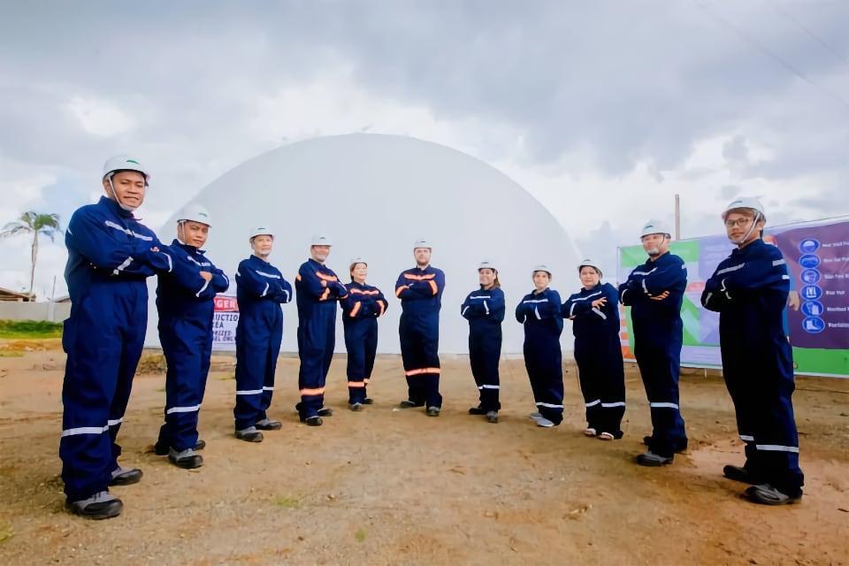 The team of Dazzling Lite Enterprises in front of their rice storage dome.